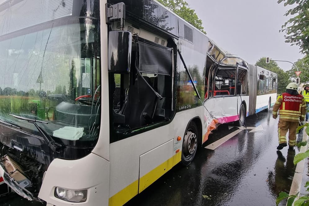 Ein Feuerwehrmann steht bei einem beschädigten Linienbus: Bei einem Zusammenstoß zwischen einem Linienbus und einem Lkw ist ein Mensch tödlich verletzt worden.