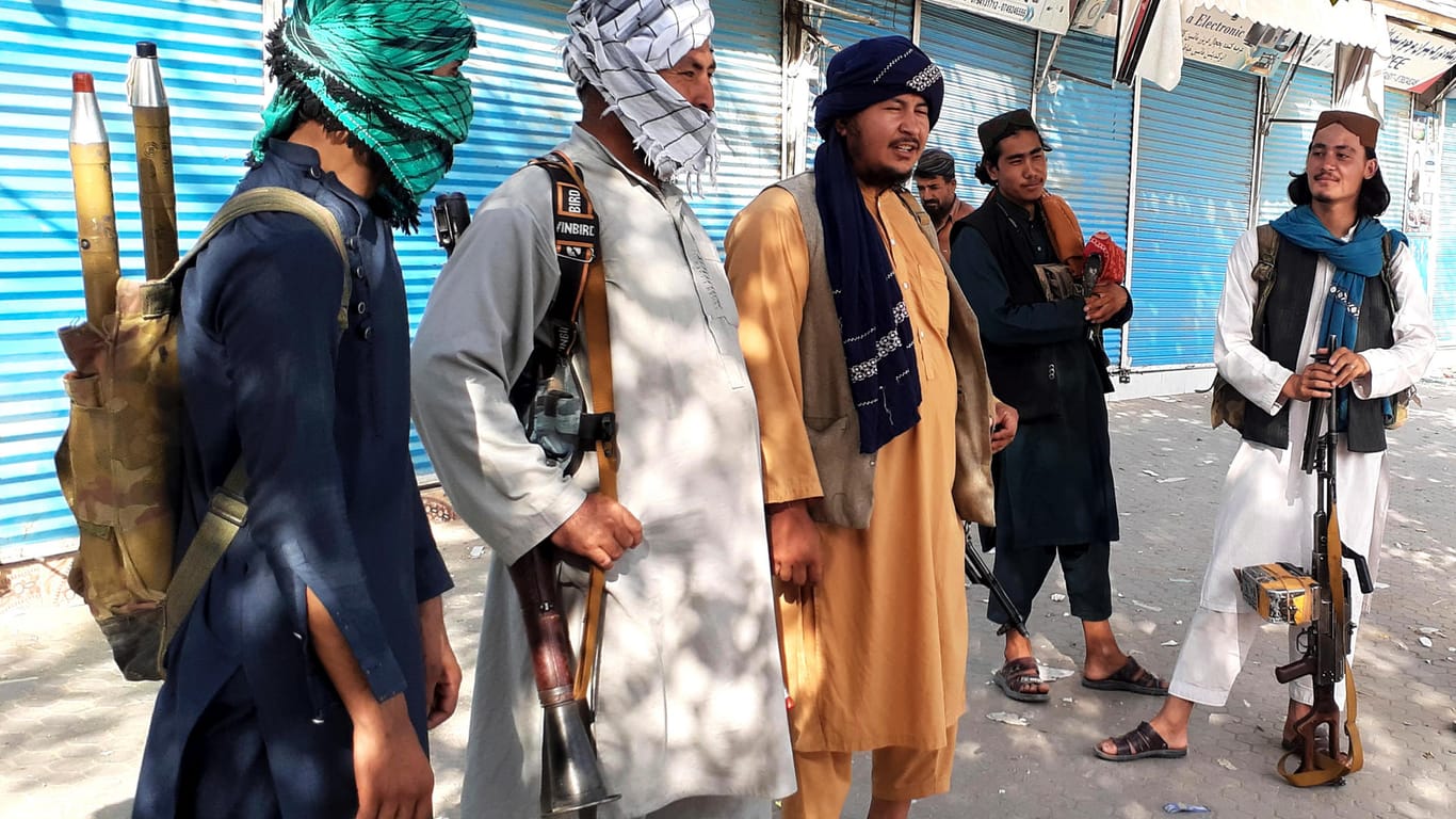Taliban-Kämpfer stehen am Montag Wache an einer Straße in Kundus. Die USA wollen bei ihrem Abzugsplan bleiben.