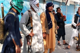 Taliban-Kämpfer stehen am Montag Wache an einer Straße in Kundus. Die USA wollen bei ihrem Abzugsplan bleiben.