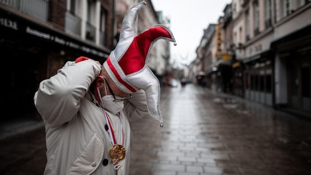 Ein Mann steht mit Karnevals-Mütze in einer Straße in der Düsseldorfer Altstadt (Archivbild): Ein negativer Corona-Test reiche nicht für den Schutz vor dem Virus. Ein Mann steht mit Karnevals-Mütze in einer Straße in der Düsseldorfer Altstadt (Archivbild): Ein negativer Corona-Test reiche nicht für den Schutz vor dem Virus.