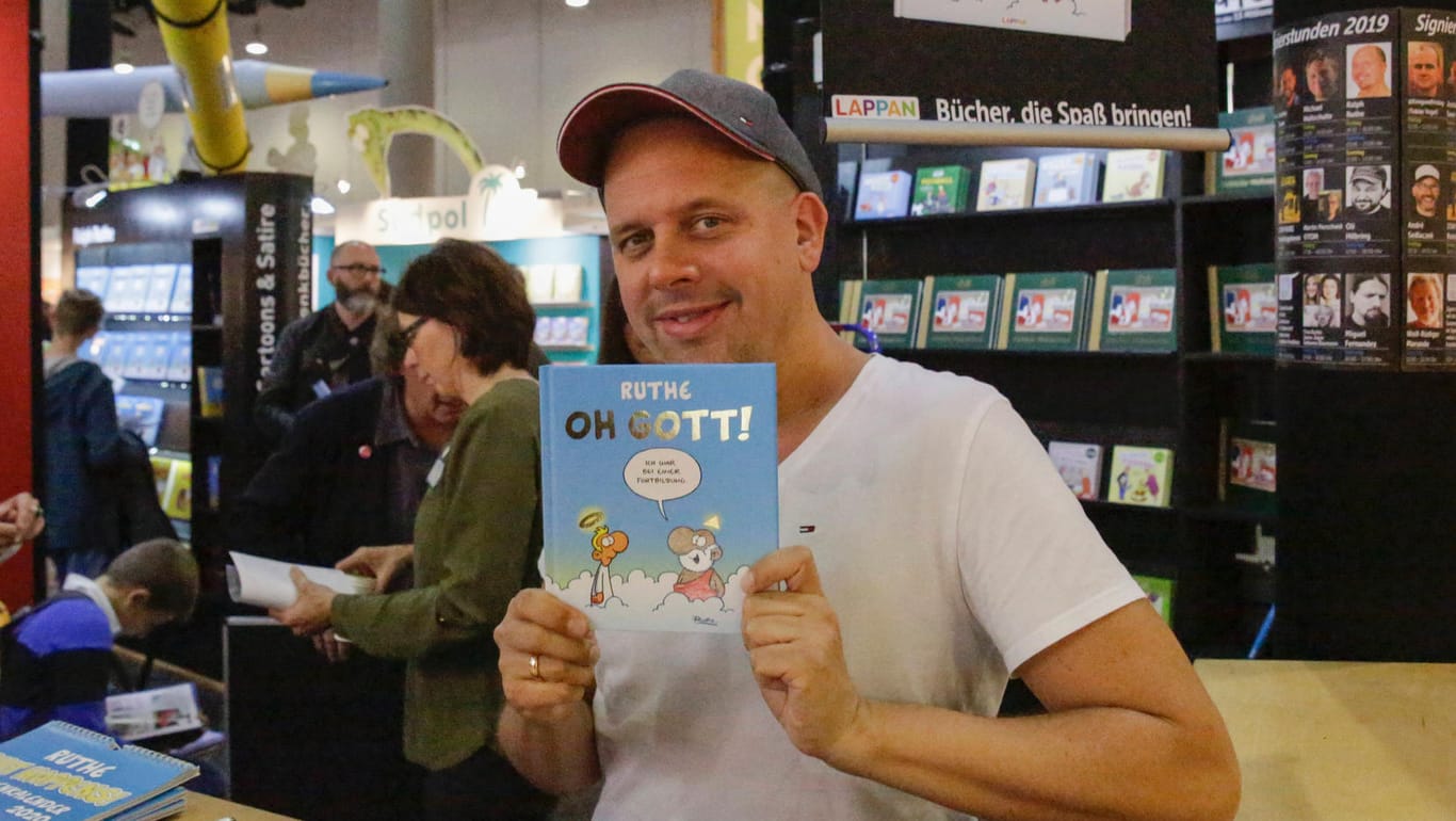 Germany: Frankfurt Book Fair 2019 Day 3 German cartoonist Ralph Ruthe holds up his latest book at the Frankfurt Book Fa