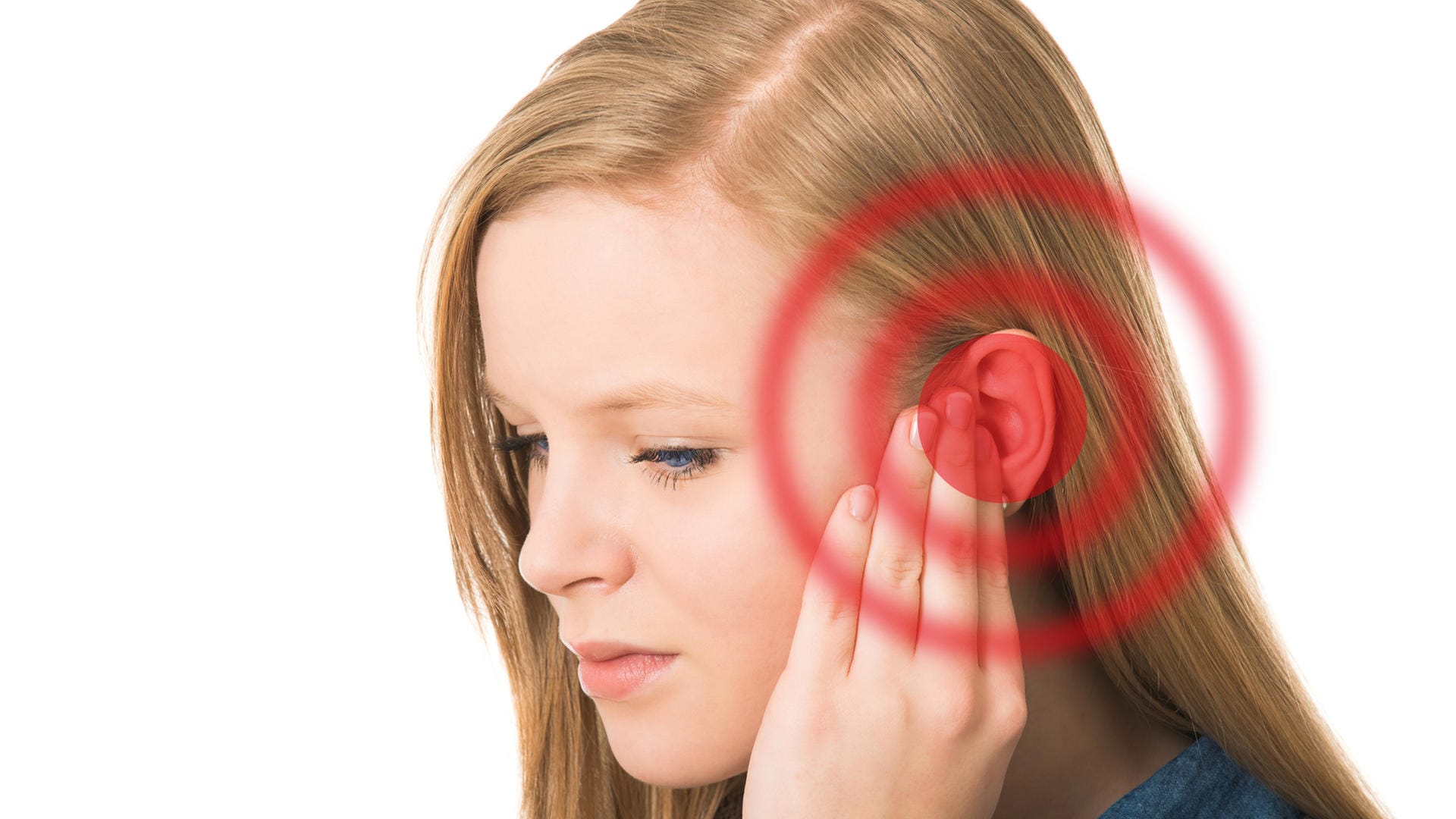 Eine junge Frau hält die linke Hand an ihr Ohr. Tinnitus kann viele Ursachen haben und verschwinden häufig von selbst. Halten sie Ohrgeräusche jedoch länger als 48 Stunden an, sollte man einen Arzt aufsuchen.