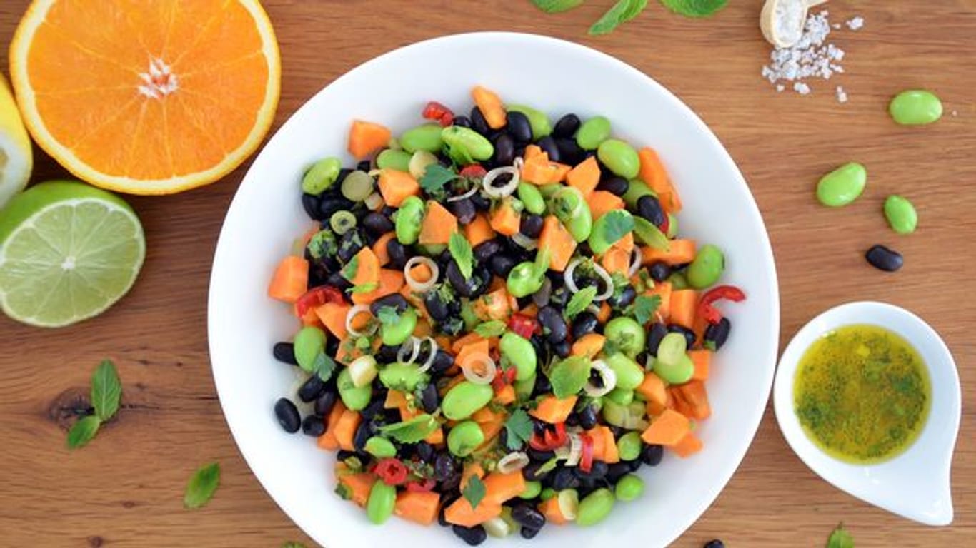 Leuchtend grüne Punkte vermischen sich mit dunklen und orangenen Farbtupfern: Zusammen mit dem Zitrusfrüchte-Dressing wird der nussig-würzige Bohnen-Mix zu einem frischen Salat.