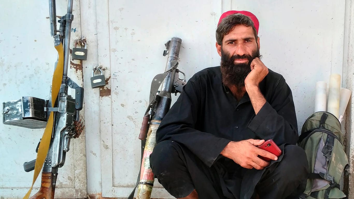 Ein Taliban-Kämpfer sitzt im afghanischen Farah neben seinen Waffen: Die militant-islamistischen Taliban rücken schnell vor.