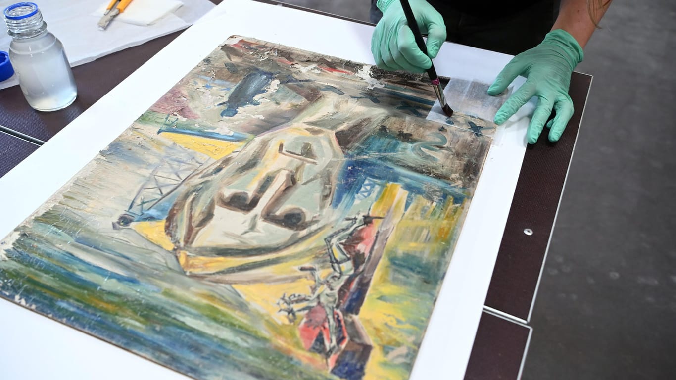 In einem Depot des Zentrums für Kunst und Medien (ZKM) wird an dem durch Hochwasser beschädigten Gemälde "Selbstporträt" von Ernst Kley eine Notsicherung mit Japanpapier vorgenommen.