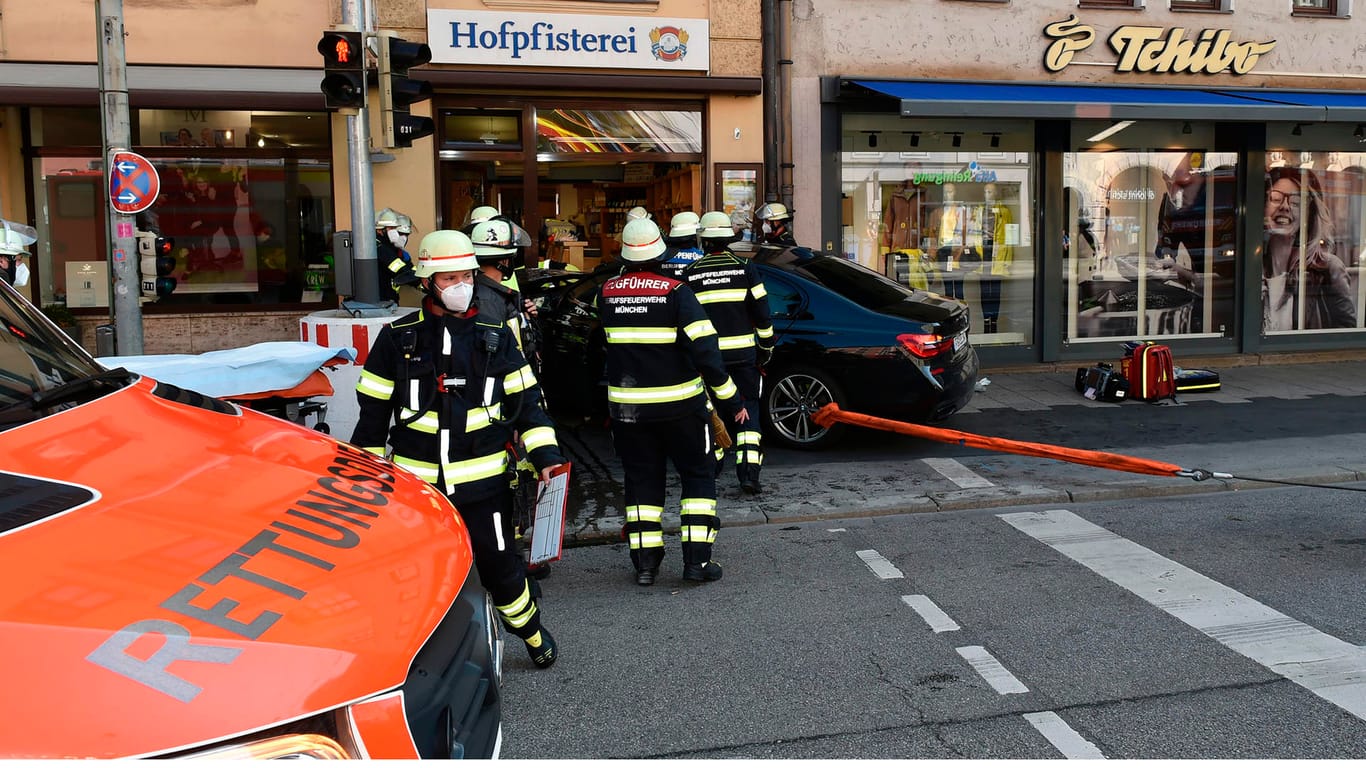 Die Feuerwehr zieht das Auto mit einer Seilwinde aus der Bäckerei: Drei Menschen wurden bei dem Unfall in München verletzt.