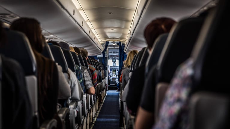 In einem Flugzeug sitzen Passagiere (Symbolbild): Mehrere hatten gefälschte Corona-Tests dabei.