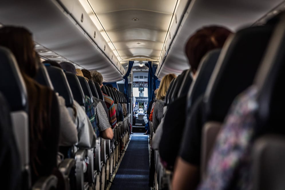 In einem Flugzeug sitzen Passagiere (Symbolbild): Mehrere hatten gefälschte Corona-Tests dabei.