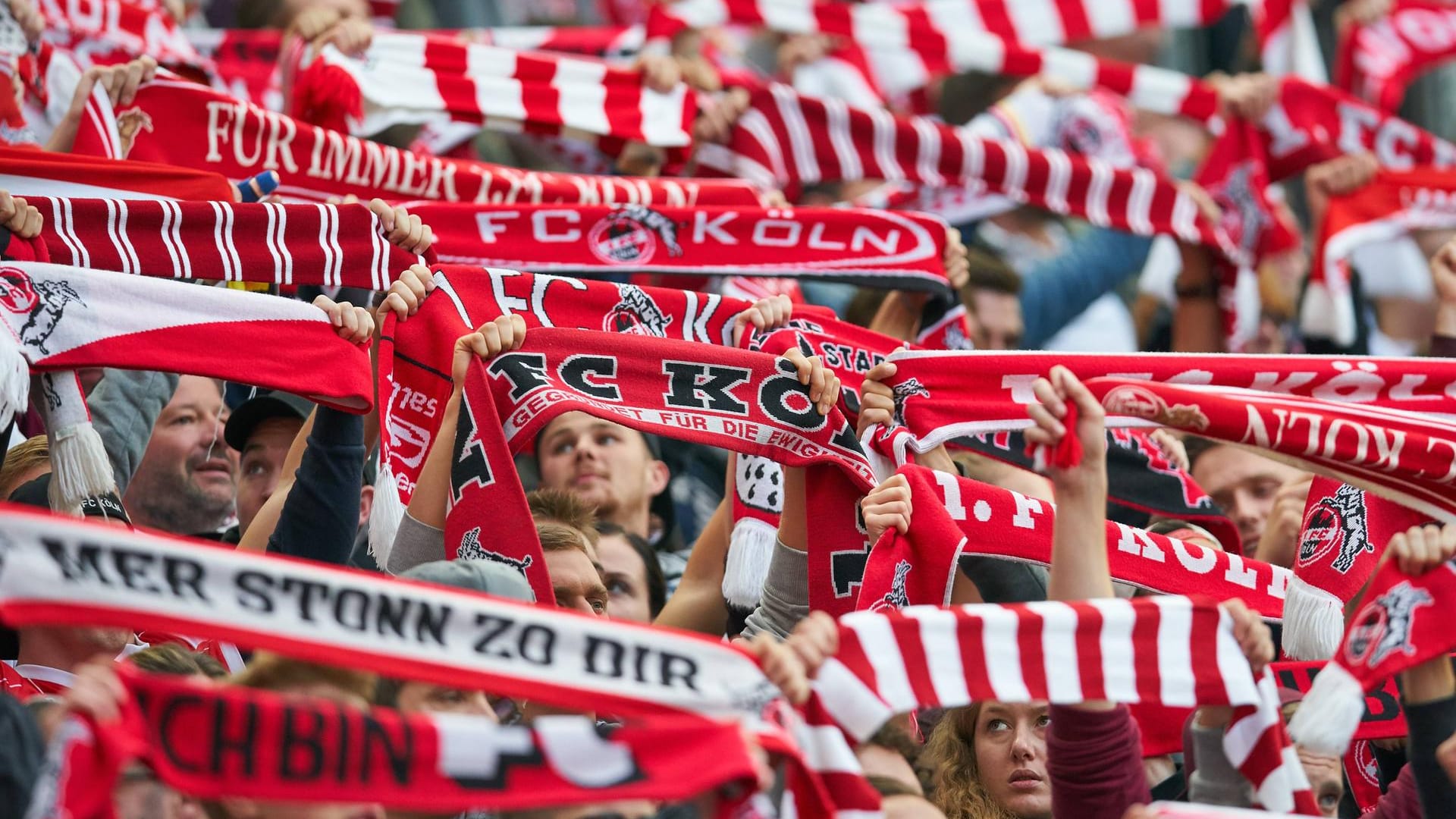 FC-Fans halten Vereinsschals in die Luft (Archivbild): Zum Saisonstart dürfen erstmals seit Beginn der Corona-Krise wieder Tausende Zuschauer ins Stadion.