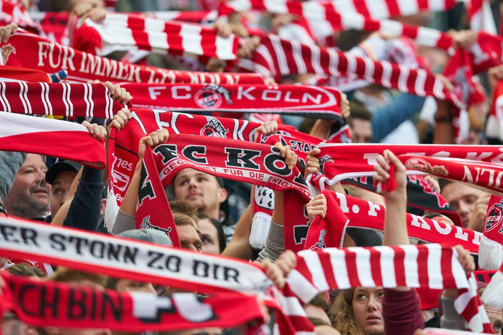 FC-Fans halten Vereinsschals in die Luft (Archivbild): Zum Saisonstart dürfen erstmals seit Beginn der Corona-Krise wieder Tausende Zuschauer ins Stadion.