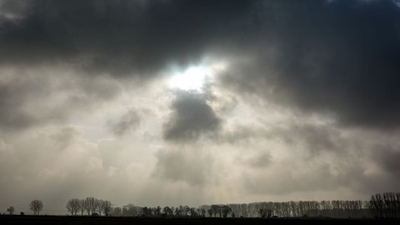 Die Sonne kommt hinter einer dunklen Wolkendecke hervor