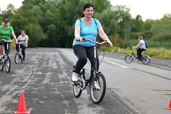 Sicherer radeln: Monika Kraus (vorn) aus Marburg nimmt an einem Radfahrkurs auf dem Alten Flugplatz im Stadtteil Bonames teil. Die Kurse wenden sich gleichermaßen an Anfänger, Wiedereinsteiger und an unsichere Radfahrerinnen und Radfahrer.