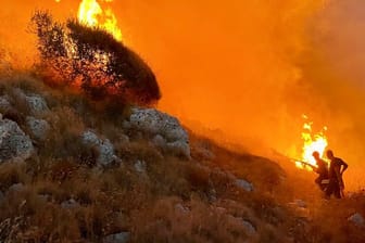Feuer im italienischen Badeort Porto Badisco an der Adriaküste: Feuerwehrleute versuchen, die Waldbrände einzudämmen.
