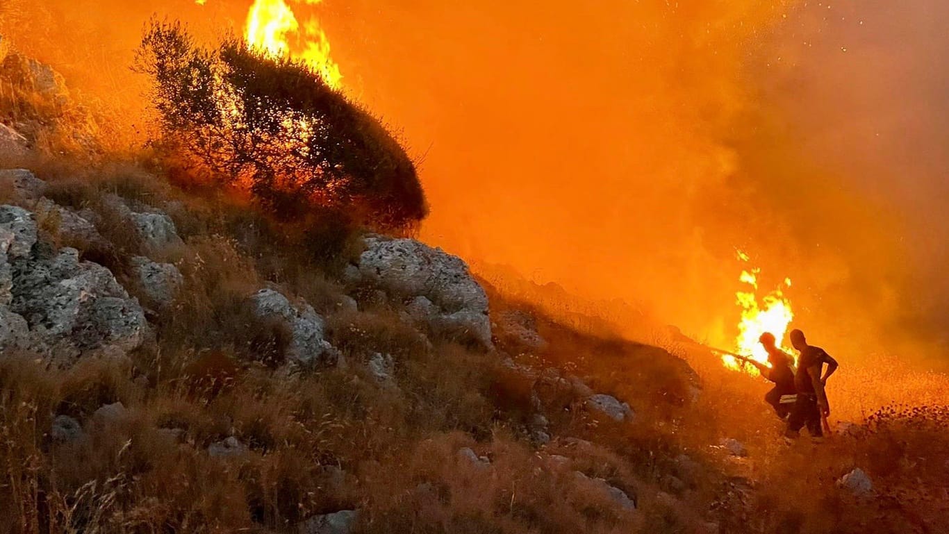 Feuer im italienischen Badeort Porto Badisco an der Adriaküste: Feuerwehrleute versuchen, die Waldbrände einzudämmen.