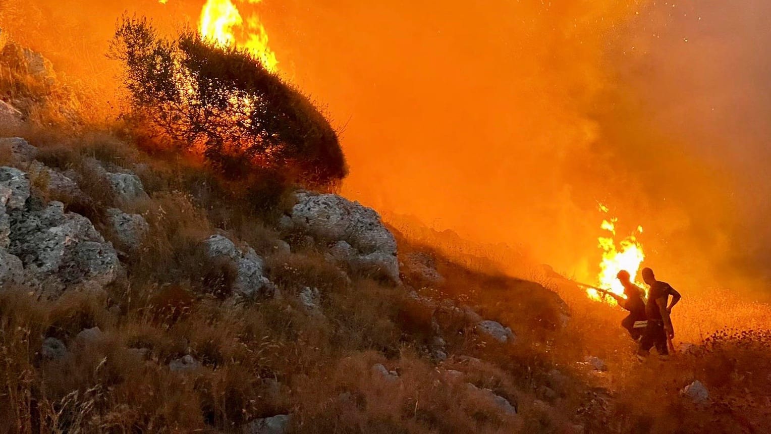 Feuer im italienischen Badeort Porto Badisco an der Adriaküste: Feuerwehrleute versuchen, die Waldbrände einzudämmen.