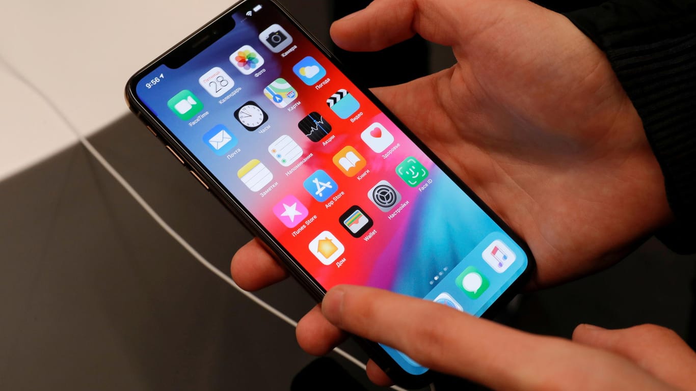 Ein Kunde hält ein iPhone in der Hand (Symbolbild). Apple hat angekündigt, seine Bildanalyse bei Kinderpornografie zu verfeinern.