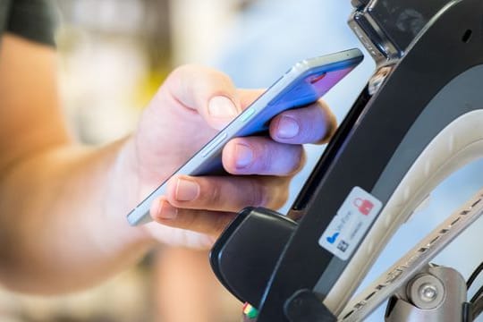 Ein Smartphone wird an ein Kassenterminal gehalten.