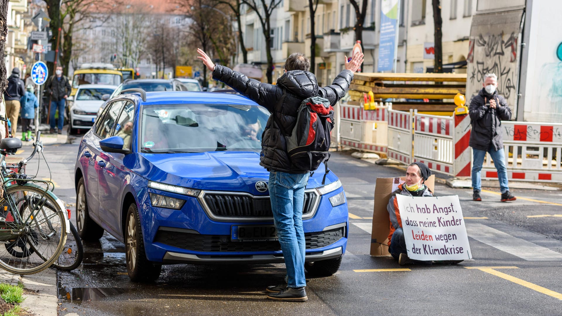 Ein Rebell von Extinction Rebellion blockiert allein die Straße: Hier wird er spontan von einem Passanten unterstützt.