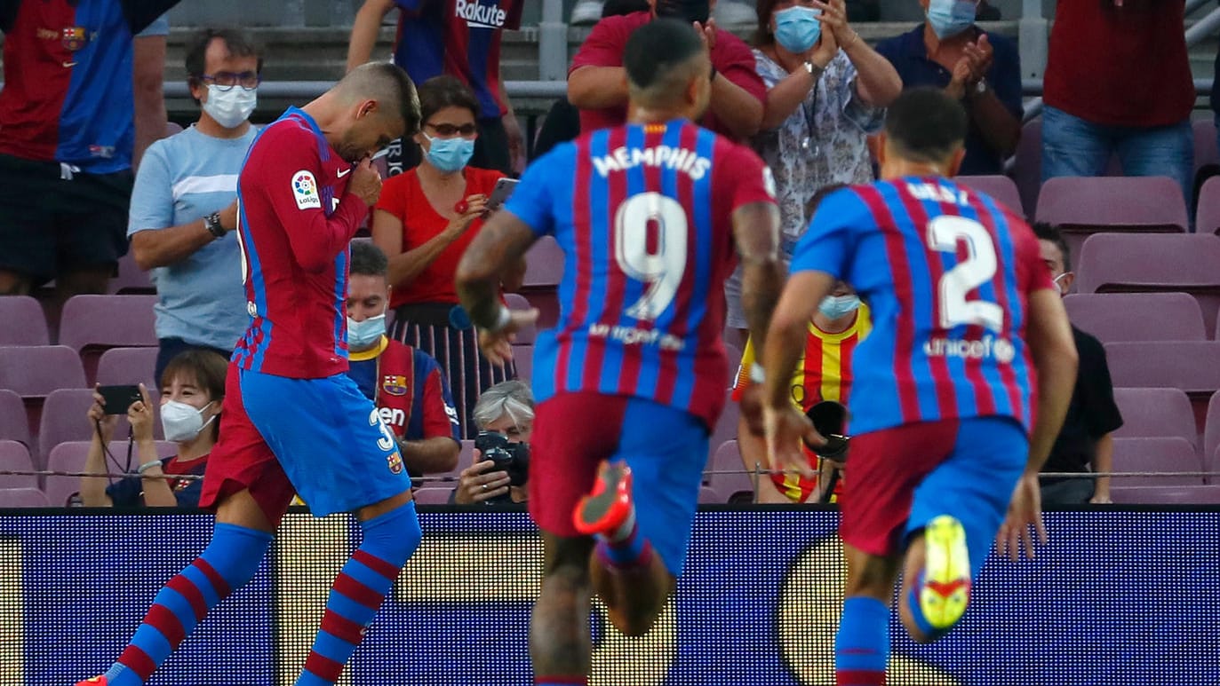 Gerard Piqué (l.) küsst das Wappen auf seinem Trikot.