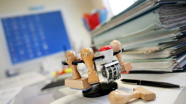 Ein Stempelkarussell steht neben einem Stapel Akten Ein Stempelkarussell steht neben einem Stapel Akten