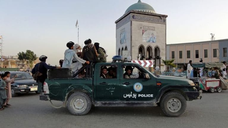 Taliban-Kämpfer patrouillieren in einem Polizeifahrzeug in Kandahar.