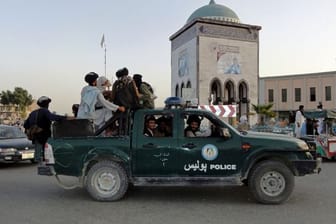 Taliban-Kämpfer patrouillieren in einem Polizeifahrzeug in Kandahar.