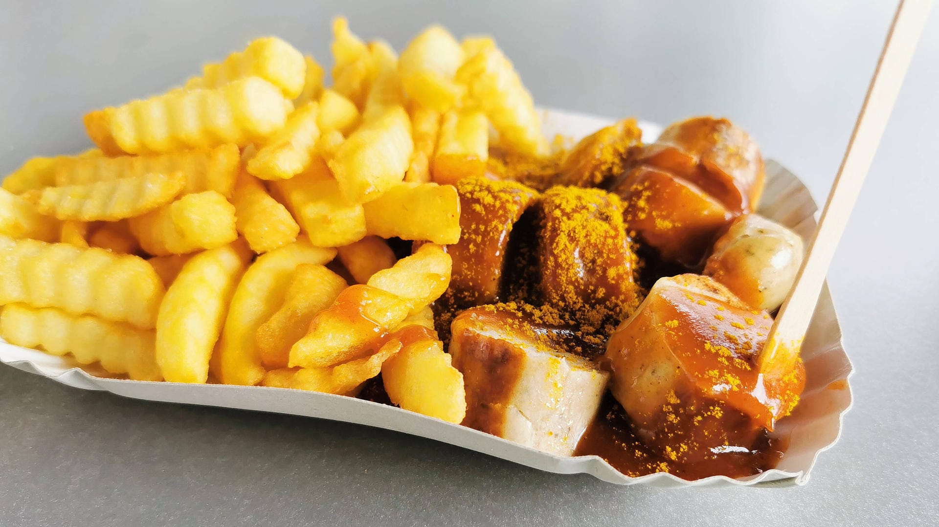 Currywurst mit Pommes: Eine Bloggerin aus den USA kritisiert, der Begriff "Curry" gehe wohl auf die Bequemlichkeit der Kolonialherren in Indien zurück.