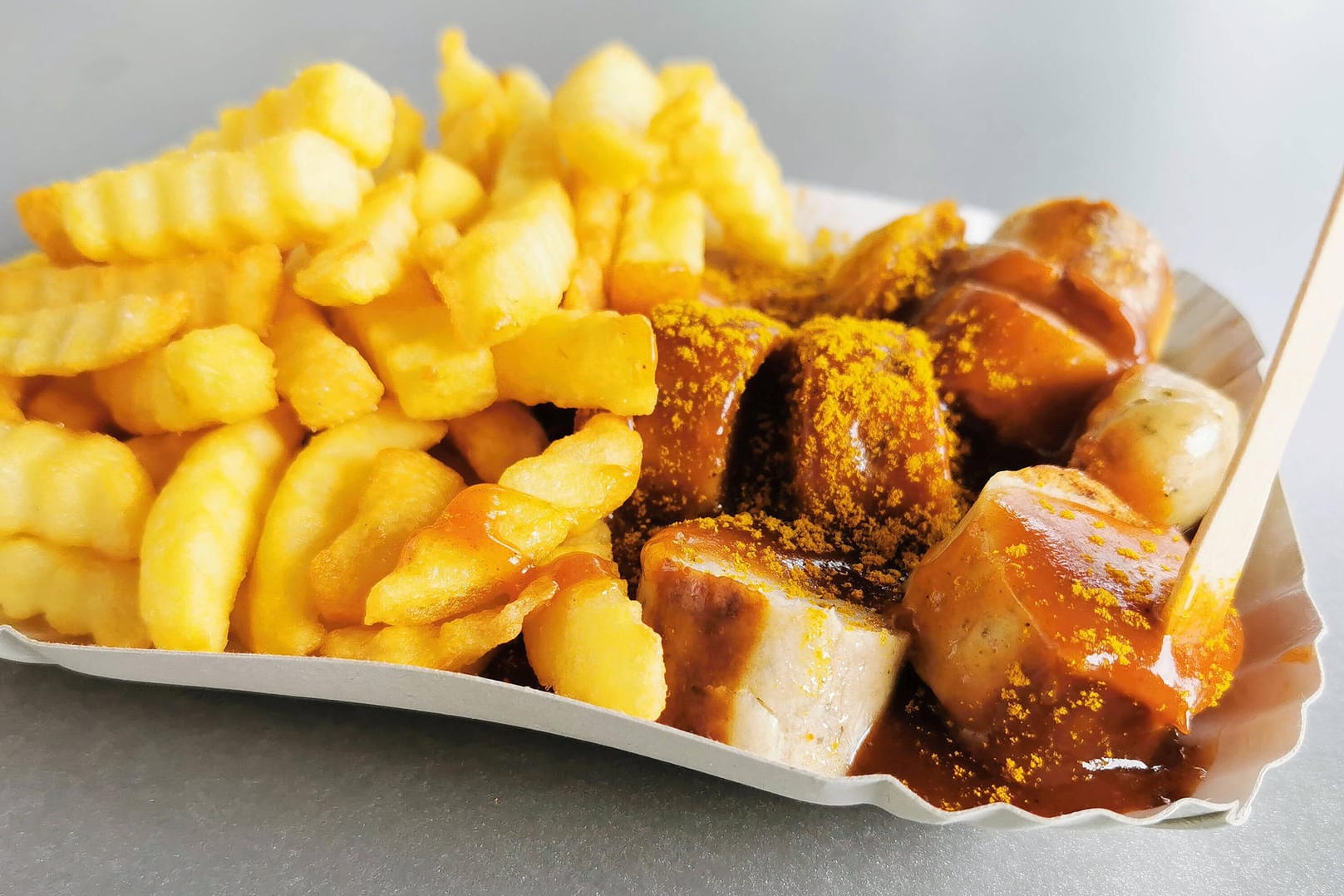 Currywurst mit Pommes: Eine Bloggerin aus den USA kritisiert, der Begriff "Curry" gehe wohl auf die Bequemlichkeit der Kolonialherren in Indien zurück.