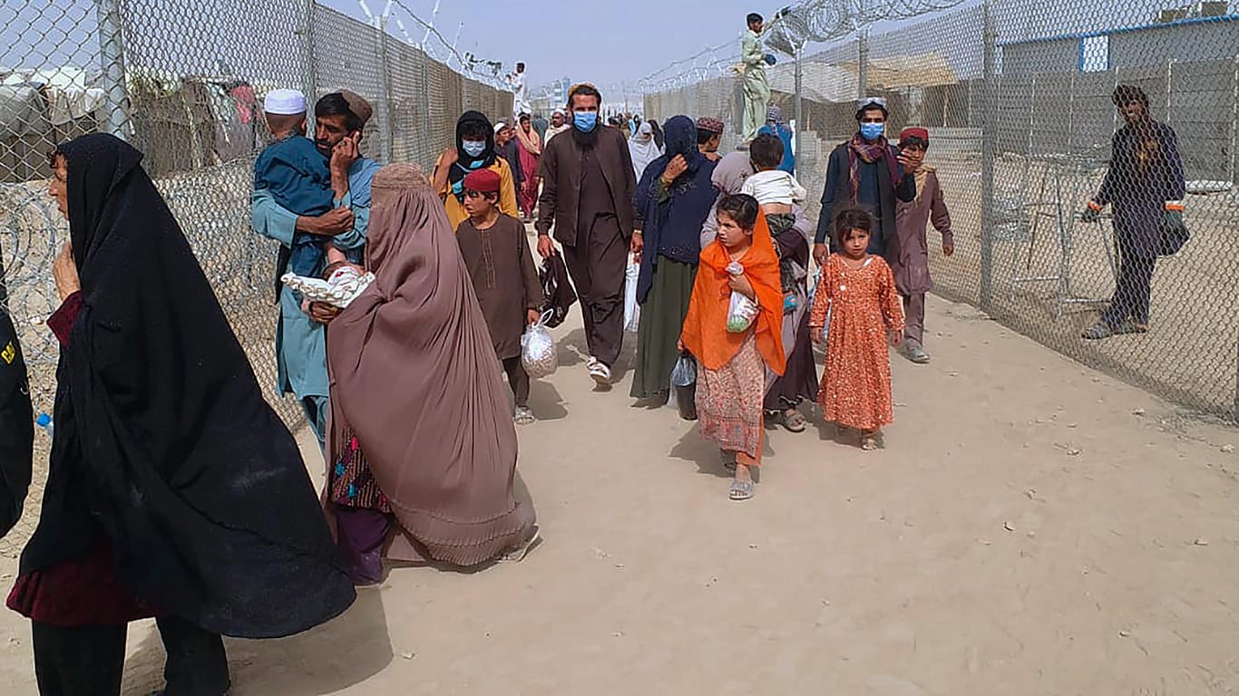 Pakistan: Menschen aus Afghanistan überqueren einen Grenzübergang, nachdem die Taliban die Macht im Land übernommen haben.