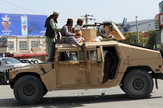 Taliban-Kämpfer vor dem internationalen Flughafen Hamid Karzai in Kabul: Tausende von Menschen stürmten am Montag das Rollfeld und drängten im verzweifelten Versuch, aus dem Land zu kommen, in die Flugzeuge.