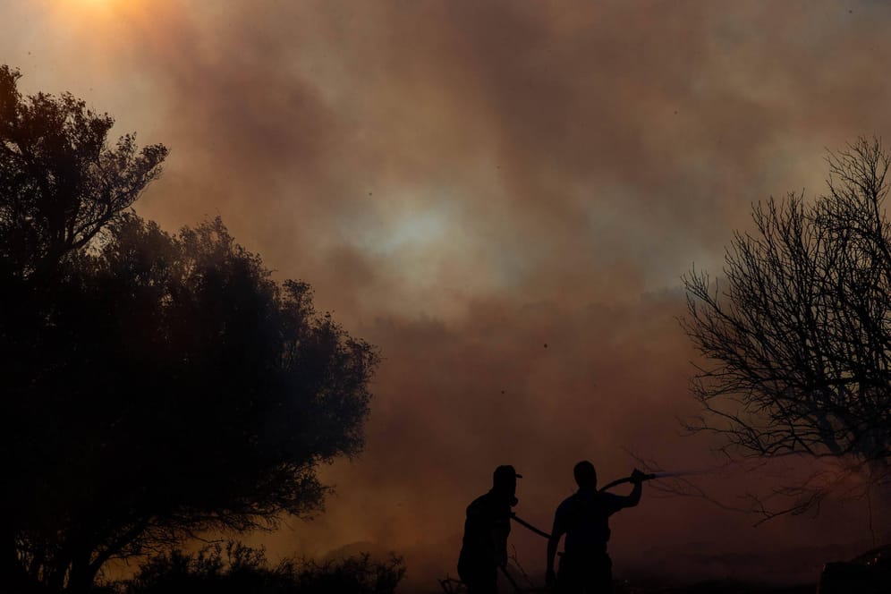 Feuerwehrleute nahe Athen: Seit Wochen kommt es in Griechenland immer wieder zu heftigen Waldbränden.
