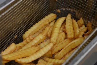 Pommes Frites in einer Fritteuse (Symbolbild): Der Imbissmitarbeiter verletzte sich an beiden Schienbeinen.