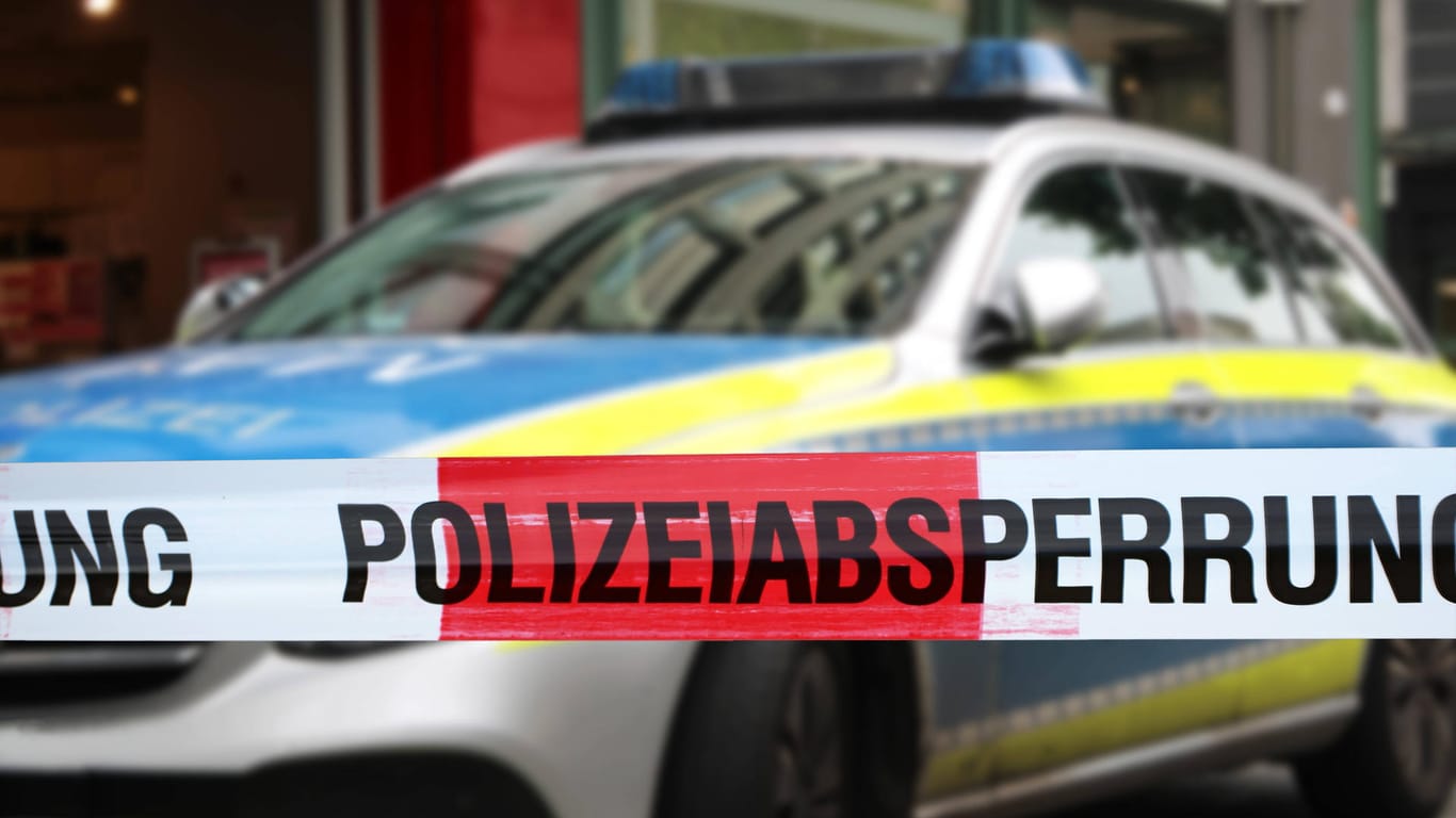 Polizeiabsperrung mit Polizeiauto im Hintergrund (Symbolbild): In Nürnberg hat ein Mann einem anderen in den Bauch gestochen.
