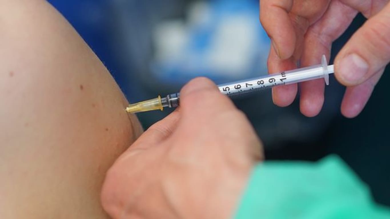 Ein medizinischer Mitarbeiter impft eine Frau (Symbolbild): Die Zahl der Erstimpfungen steigt in Baden-Württemberg wieder an.