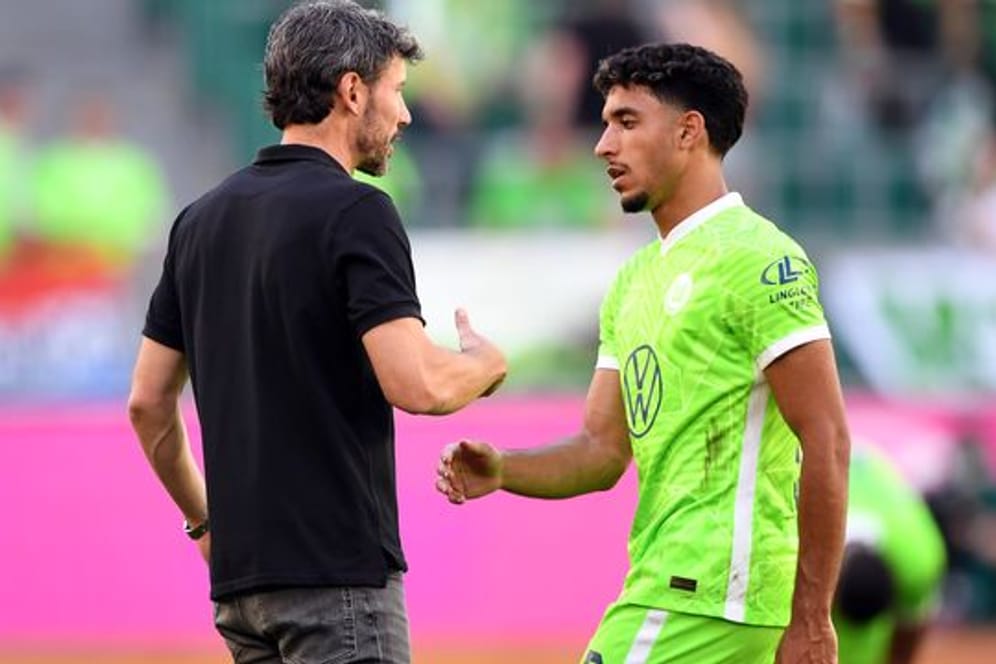 Wolfsburgs Trainer Mark van Bommel klatscht nach der Pokalpartie gegen Preußen Münster mit Omar Marmoush ab.