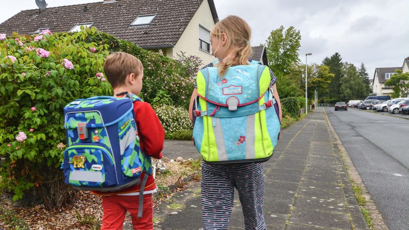 Zwei Schulkinder sind in Bonn auf dem Weg zur Schule: Nun startet das dritte Schuljahr, das von der Corona-Pandemie beeinflusst wird.