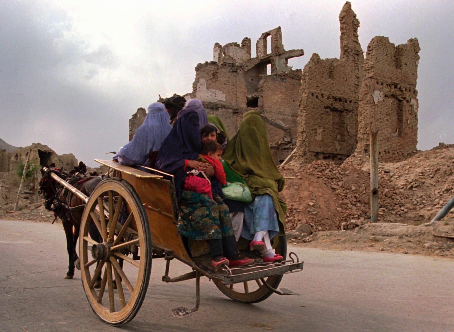 Verschleierte Frauen auf einer Pferdekutsche vor den Ruinen von Kabul: Frauen durften ab 1996 nur noch vollverschleiert aus dem Haus.