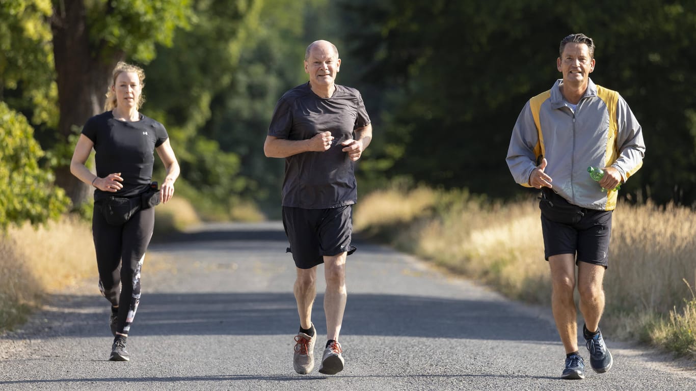 Sie dürfen ihm zum Glück nicht weglaufen: Olaf Scholz joggt mit seinen Personenschützern des BKA.