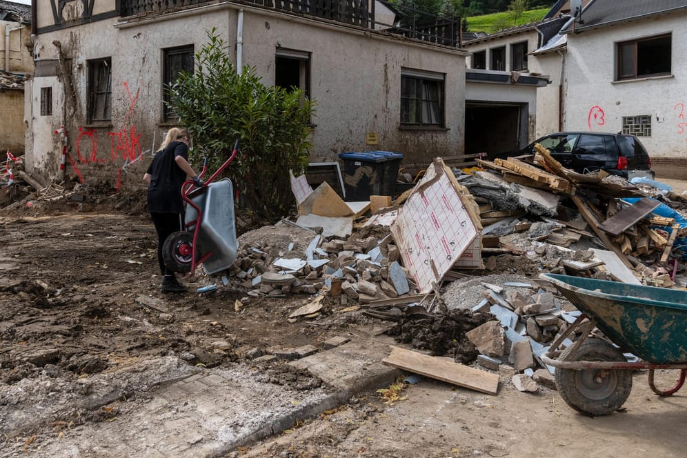 Eine Helferin leert eine Schubkarre auf einem Schutthaufen aus: Viele Häuser wurden durch die Flutkatastrophe zerstört.