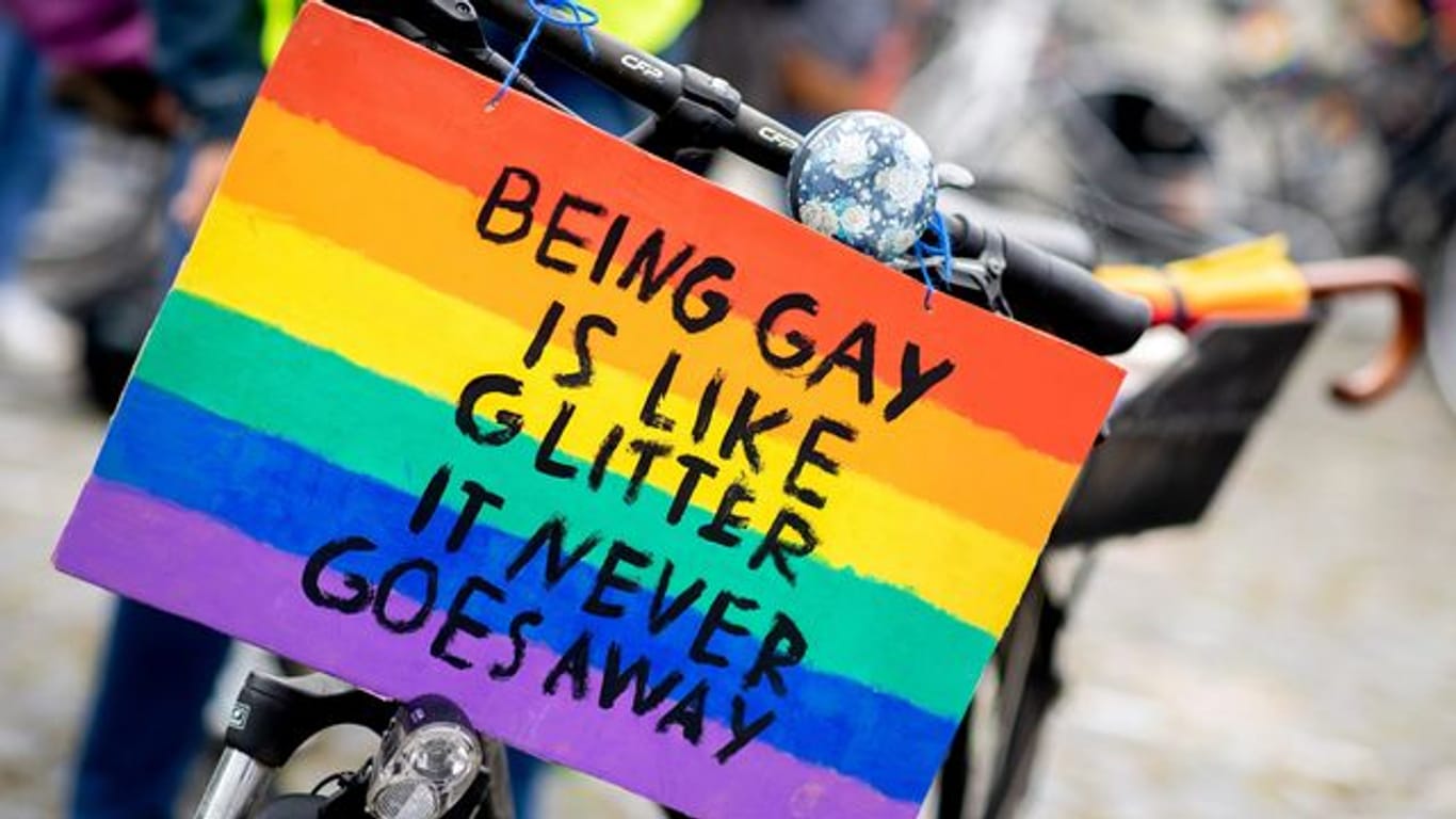 "Being gay is like glitter – it never goes away" steht zum Christopher Street Day auf einem Schild (Archivbild): Rund um die Lanxess-Arena wird es ein CSD-Veedel geben.