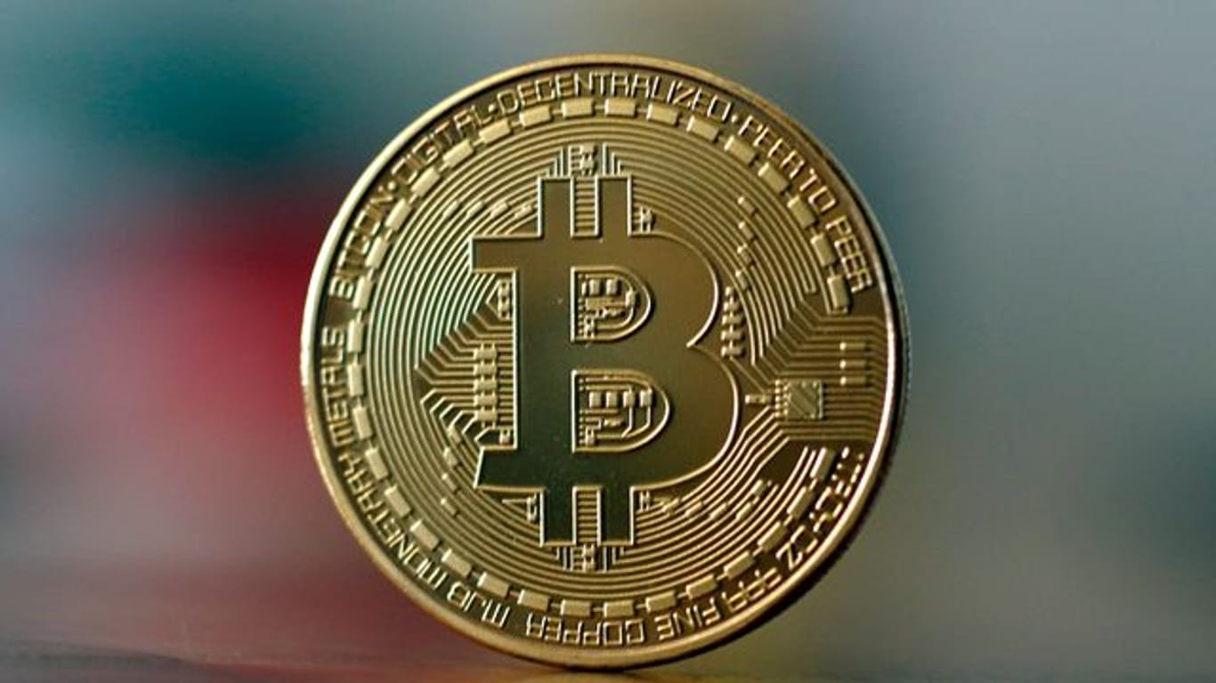 ILLUSTRATION - Eine Bitcoin Münze steht auf einem Tisch.