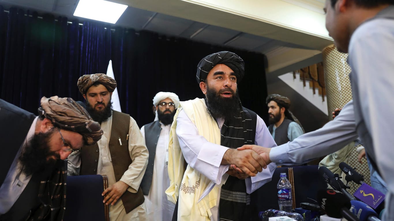 Erste Pressekonferenz der Taliban am Dienstag: Zabihullah Mujahid, Sprecher der Taliban, schüttelt einem Journalisten die Hand.