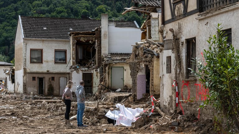 Flutkatastrophe im Ahrtal: Menschen stehen vor ihrem zerstörten Haus.
