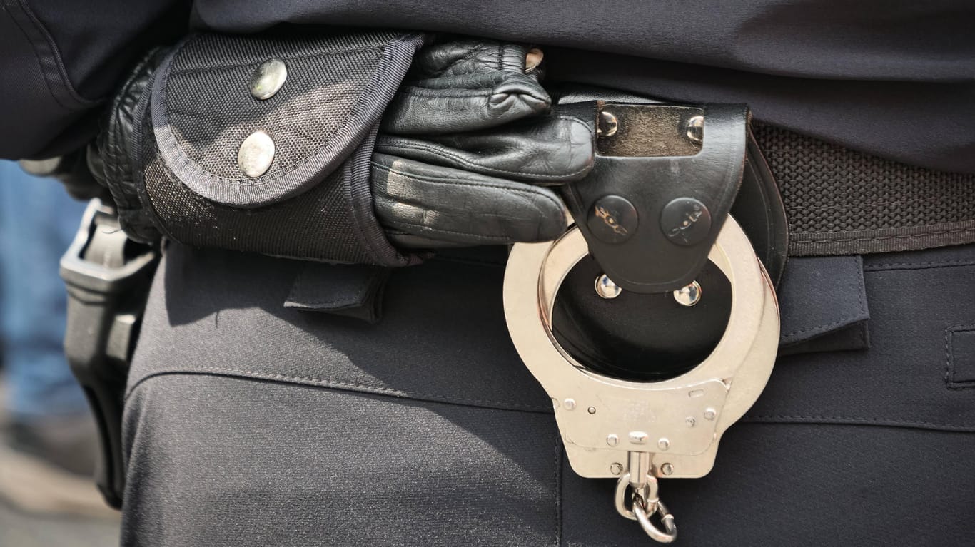 Einsatzhandschuh und Handschellen am Gürtel einer Polizeibeamtin (Symbolbild): Der Kölner Polizei ist eine Diebesbande ins Netz gegangen.