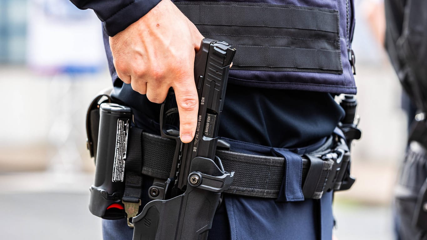 Ein Polizist hält seine Waffe fest (Symbolbild): Der Mann wurde ein ein Hamburger Krankenhaus gebracht.