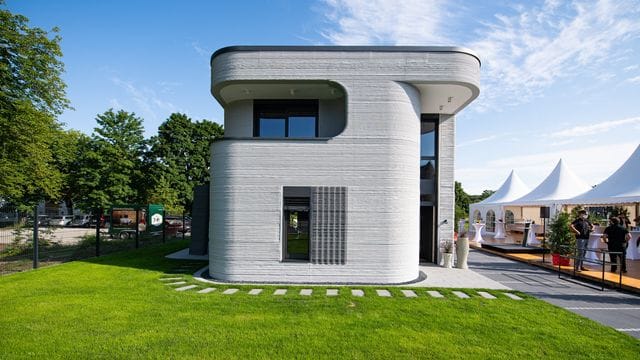 An der Außenfassade des ersten 3D Druckhauses - ein zweigeschossiges Einfamilienhaus - sieht man die mittels eines 3D-Betondrucker aufgetragenen Betonschichten.