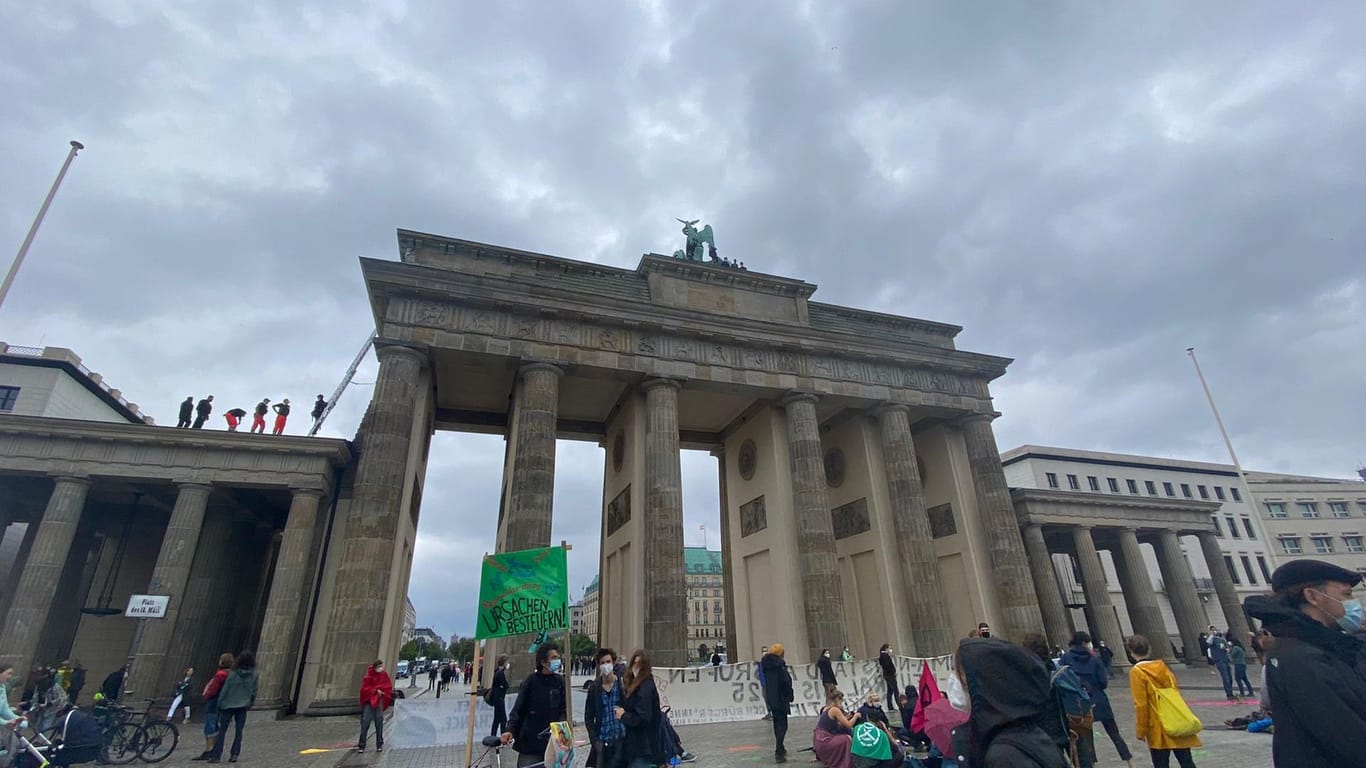 Das Brandenburger Tor am Vormittag: Während sich oben nach wie vor Aktivisten aufhielten, versammelten sich rund 200 Menschen auf dem Platz davor.