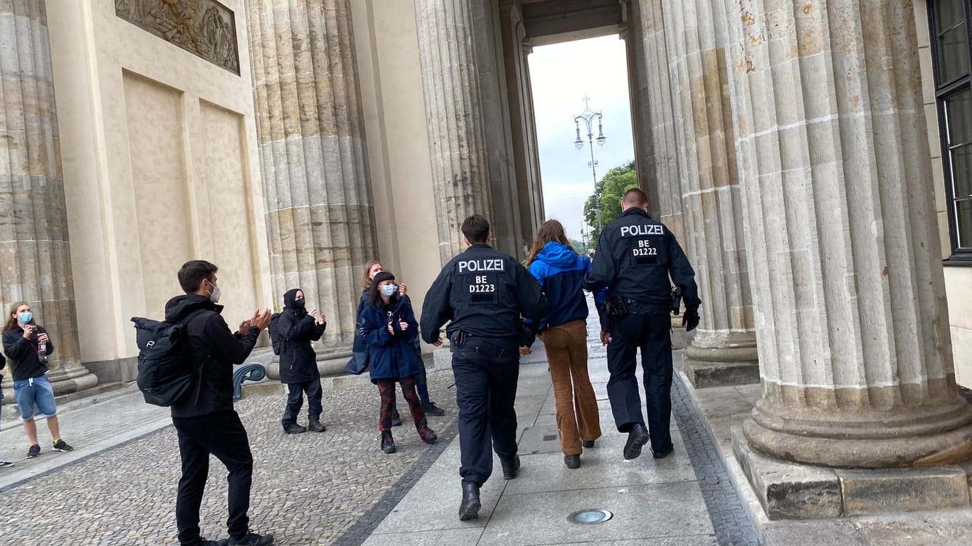 Die Polizei führt einen Aktivisten ab (Foto): Vier Stunden lang verweilten sechs Aktivisten auf dem Brandenburger Tor.