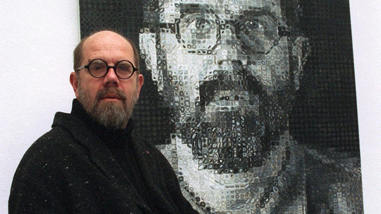 Chuck Close: Der US-amerikanische Künstler sitzt im Rollstuhl vor einem Selbstporträt von 1991. Chuck Close: Der US-amerikanische Künstler sitzt im Rollstuhl vor einem Selbstporträt von 1991.