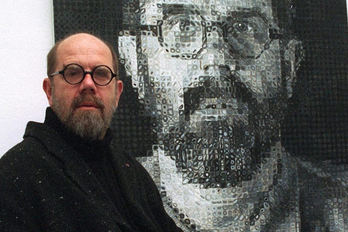 Chuck Close: Der US-amerikanische Künstler sitzt im Rollstuhl vor einem Selbstporträt von 1991.